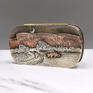 Metal hinged box depicting a fox walking through a snow covered field in the dead of night by artist Cornelius Van Dop