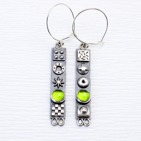 Long sterling silver earrings with 3D symbols and peridot gemstones by jewellers John and Dawn Field 