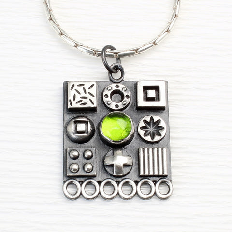 Square sterling silver pendant with 3D symbols and a peridot gemstone by jewellers John and Dawn Field 