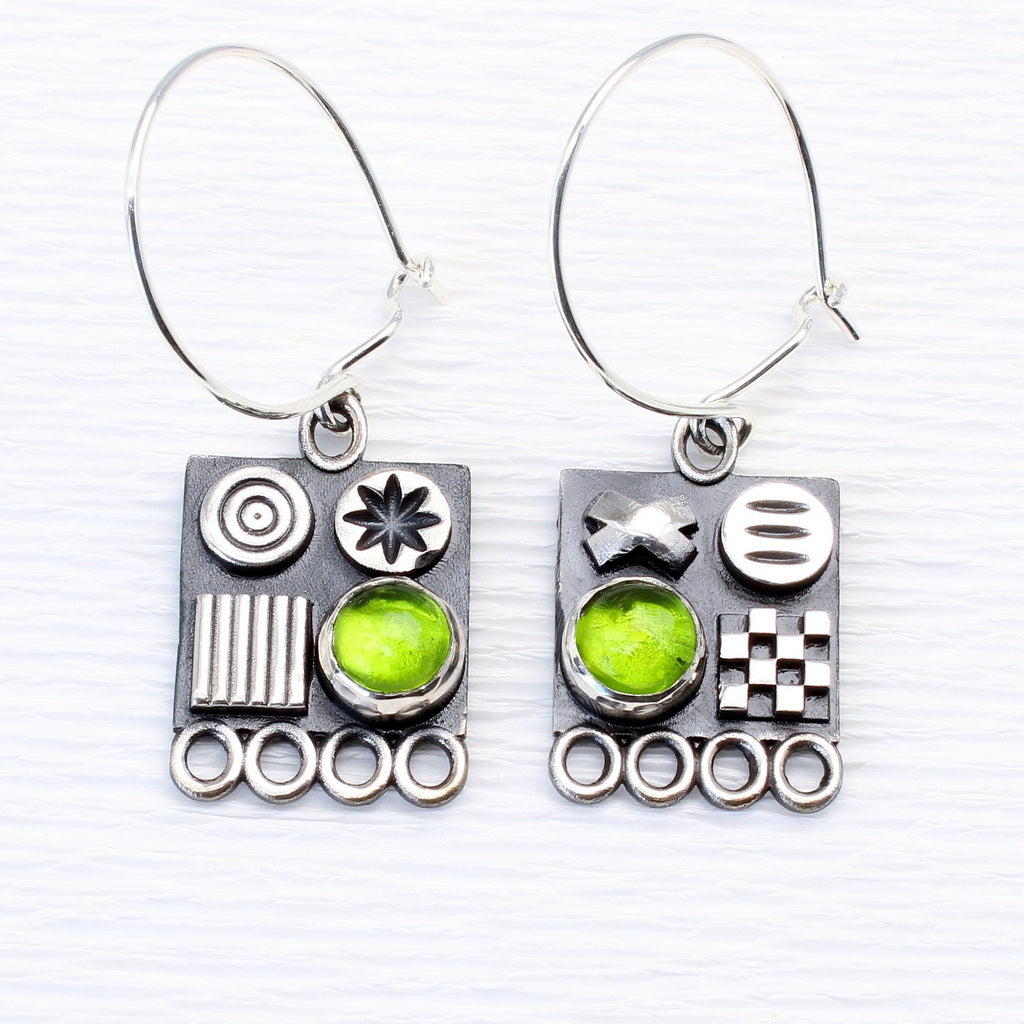 Square sterling silver earrings with 3D symbols and peridot gemstones by jewellers John and Dawn Field 