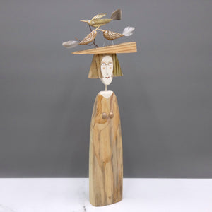 Driftwood sculpture of three birds sitting on a lady's hat by artist Lynn Muir.