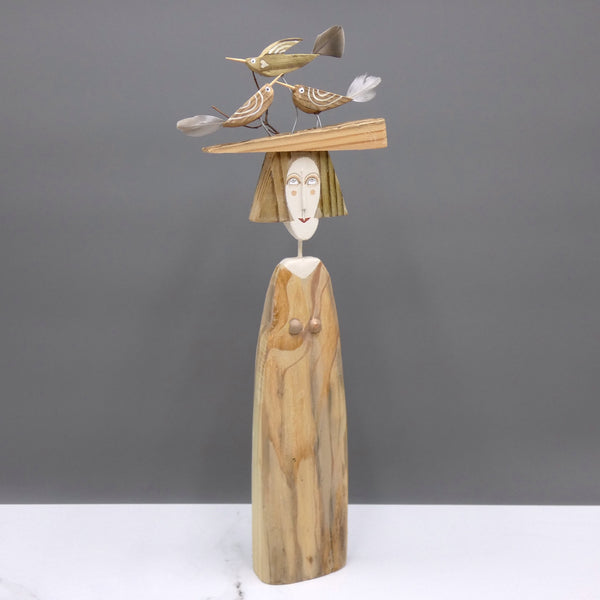 Driftwood sculpture of three birds sitting on a lady's hat by artist Lynn Muir.