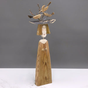 Driftwood sculpture of three birds sitting on a lady's hat by artist Lynn Muir.