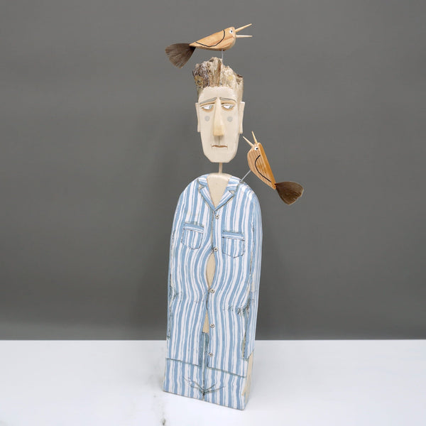 Driftwood sculpture of birds sitting on a man wearing pyjamas by artist Lynn Muir