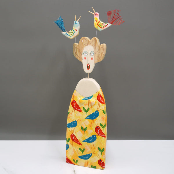 Driftwood sculpture of two singing birds sitting on a lady's head by artist Lynn Muir