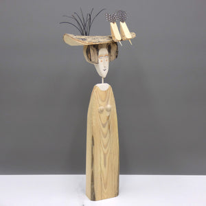 Driftwood sculpture of two birds sitting on a lady's hat by artist Lynn Muir