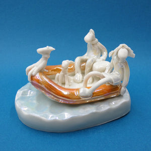 Porcelain sculpture of couple and two dogs zooming along in a rubber dinghy by artist Andrew Bull