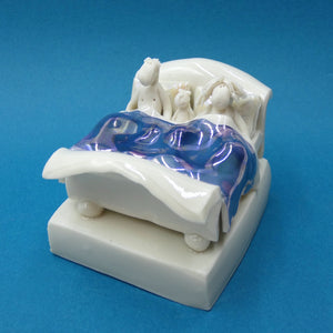 Porcelain sculpture of couple and cat in bed by artist Andrew Bull
