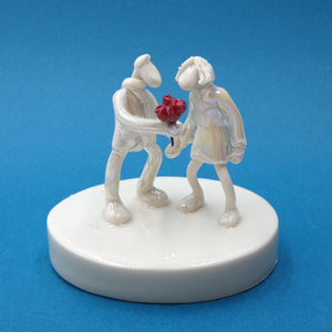 Porcelain sculpture of a man giving a woman roses by artist Andrew Bull