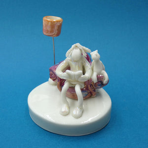 Porcelain sculpture of a lady and cat reading a book together by artist Andrew Bull