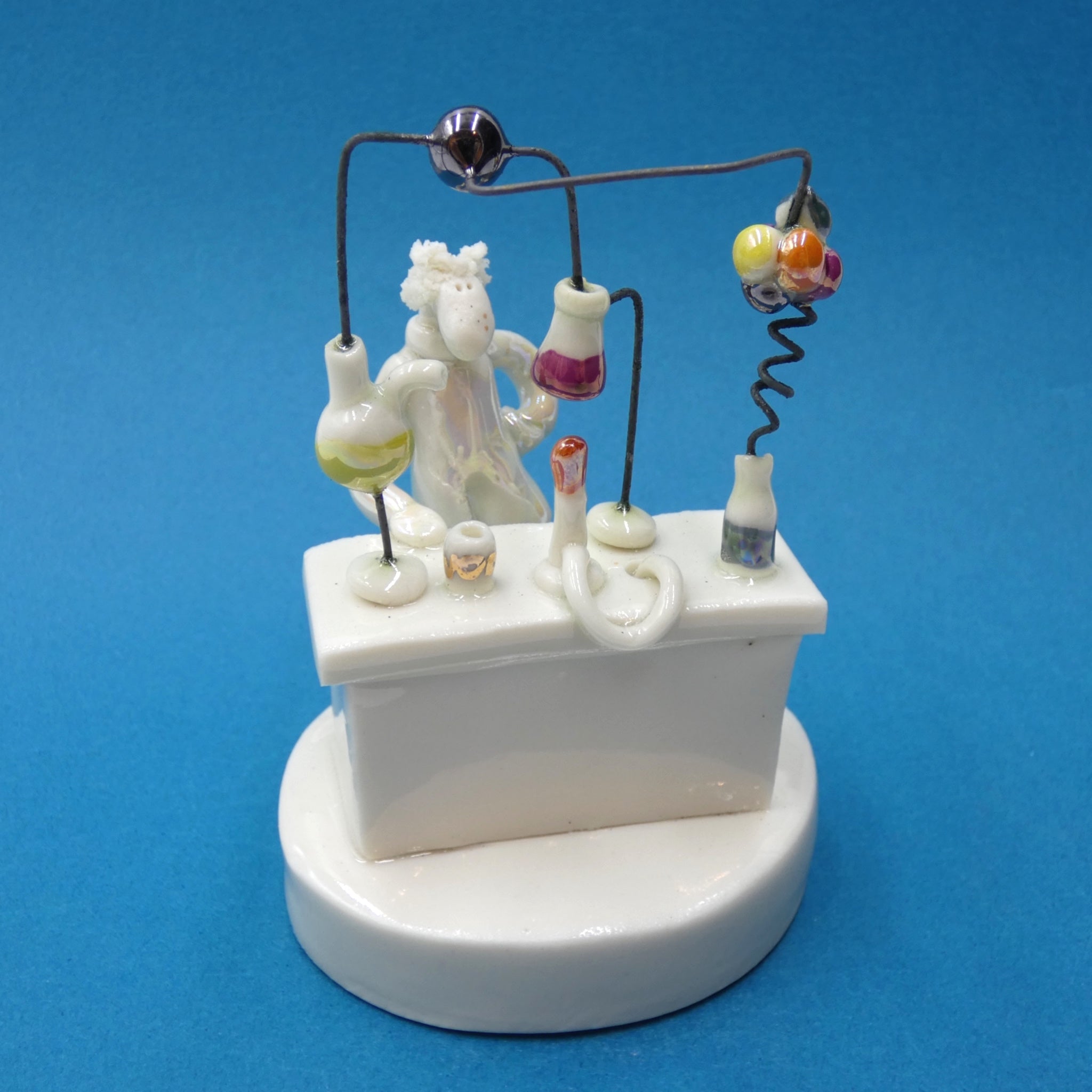 Porcelain sculpture of a scientist conducting an experiment by artist Andrew Bull