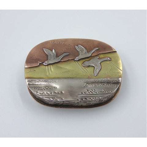 Metal hinged box depicting three geese flying over the water by artist Cornelius Van Dop