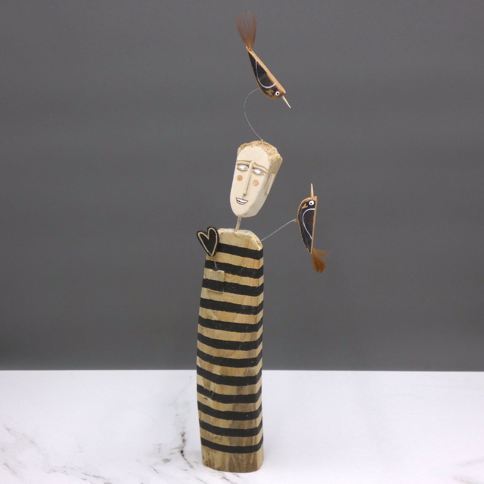 Driftwood sculpture of man with two birds by artist Lynn Muir