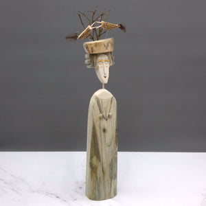 Driftwood sculpture of a woman with two birds on her hat by artist Lynn Muir
